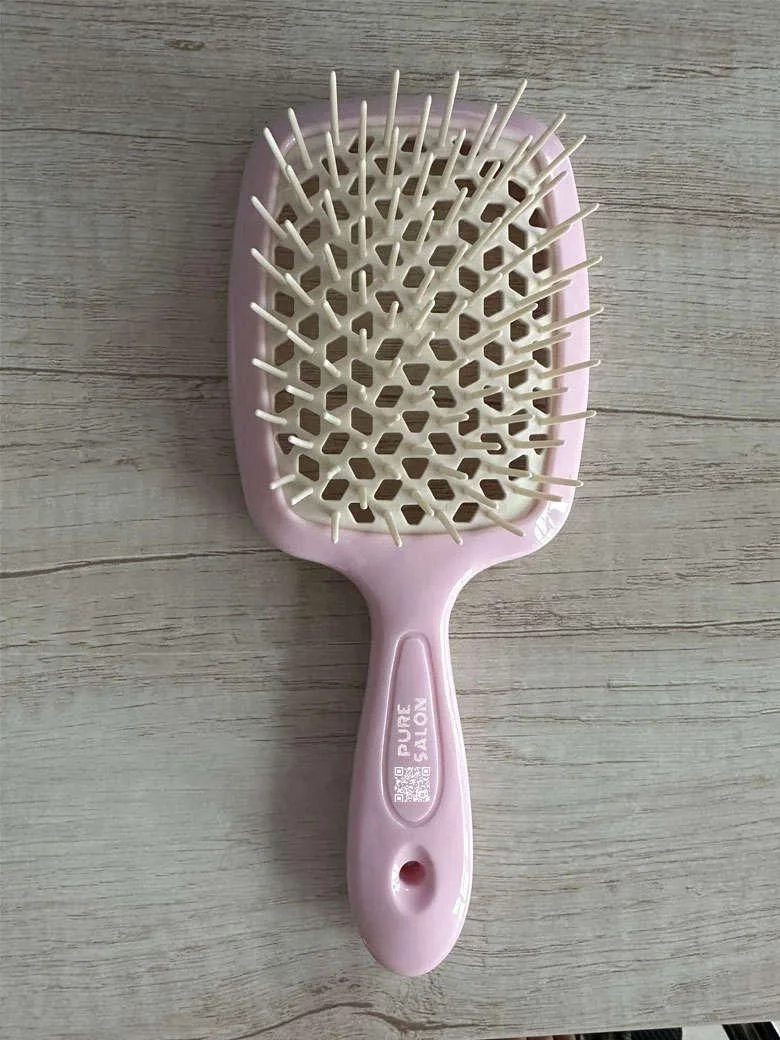 Pink Hairbrush with Soft Bristles on a Wooden Surface