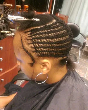 Woman Getting Hair Extensions with Cornrow Braids at a Hair Salon