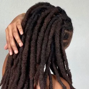 Woman with Long, Textured Hair Holding Locks with Hand